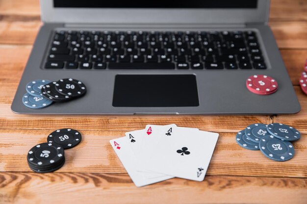 Poker-Asse und Chips auf Computer-Laptop