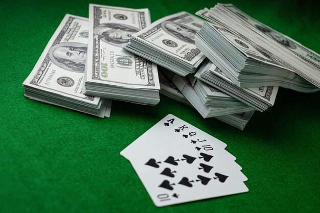 Poker casino juegos de azar Royal Straight Flush y la pila de dinero de billetes de 100 dólares estadounidenses