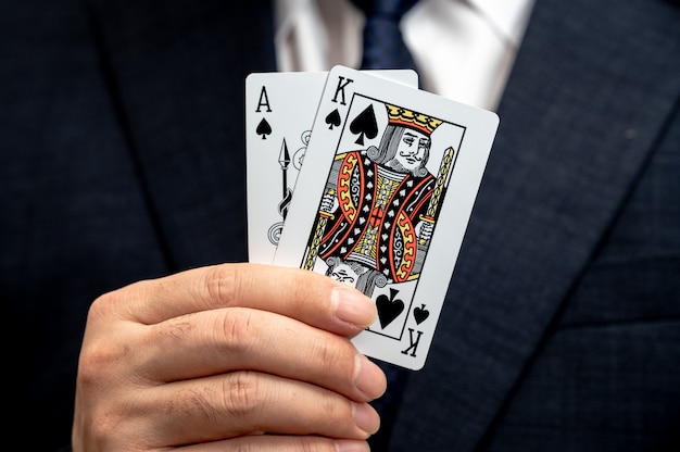 Poker-Königskarte in der Hand eines Geschäftsmannes in einer Farbe