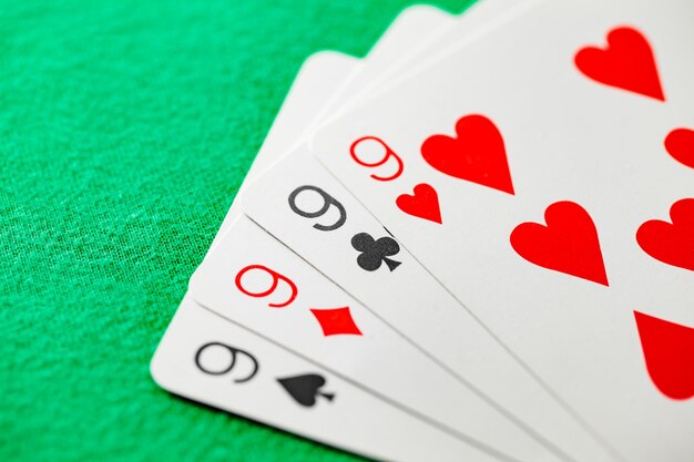 Poker-Kombination Vierer-Quads aus vier Neuner-Karten verschiedener Farben, selektiver Fokus