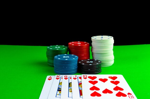 Pokerchips in Stapeln und Royal Flush-Karten auf dem Pokertisch