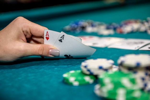 Pokerchips und weibliche Hände, die Spielkarten halten