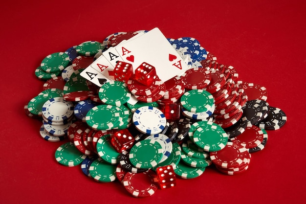 Pokerkarten und Spielchips auf rotem Grund. Ansicht von oben. Platz kopieren. Stillleben. Flach liegen. Karten - vier Asse. 4 einer Art