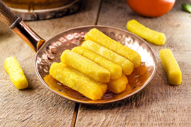 Polenta frita en una espumadera, comida típica brasileña, harina de maíz y bocadillos de harina de maíz