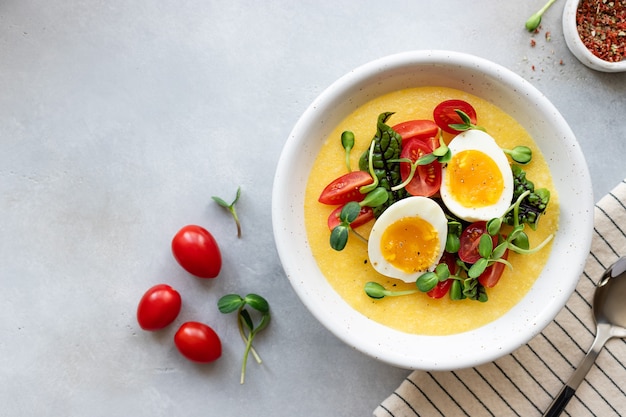 Polenta oder Maisbrei serviert mit frischem Gemüse und Eiern gesunde ausgewogene Lunch Bowl