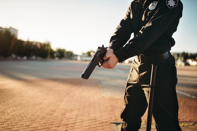 Policial masculino de uniforme com arma nas mãos