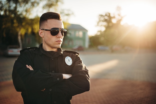 Foto policial sério de uniforme e óculos escuros