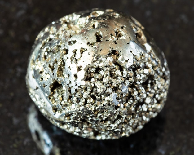 Polierter Goldfelsen des Pyritnarren auf Schwarzem