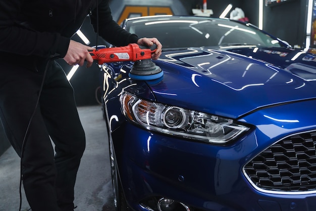 Foto polir o carro após a pintura. detalhando o carro do lado de fora. dispositivo para polir nas mãos