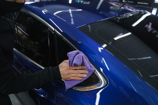 Foto polir o carro após a pintura. detalhando o carro do lado de fora. dispositivo para polir nas mãos