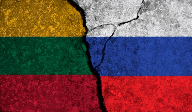 Politische Beziehung zwischen litauischen und russischen Nationalflaggen auf gerissenem Betonhintergrund