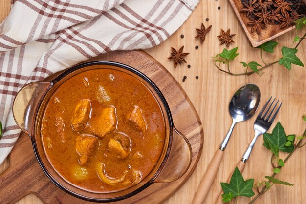 Pollo al curry con especias sobre fondo de madera