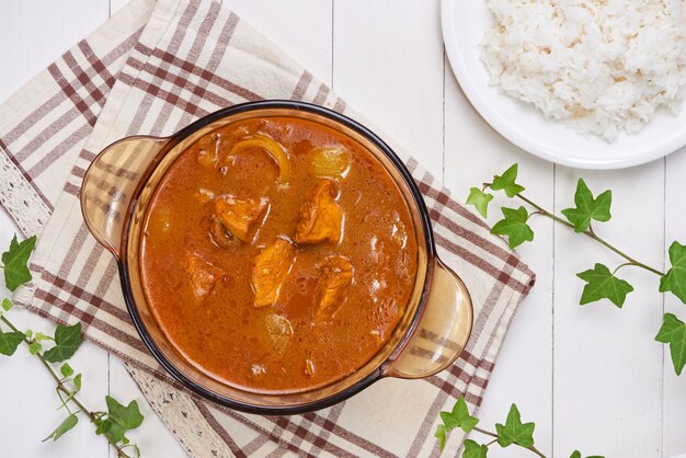 Pollo al curry con especias sobre fondo de madera