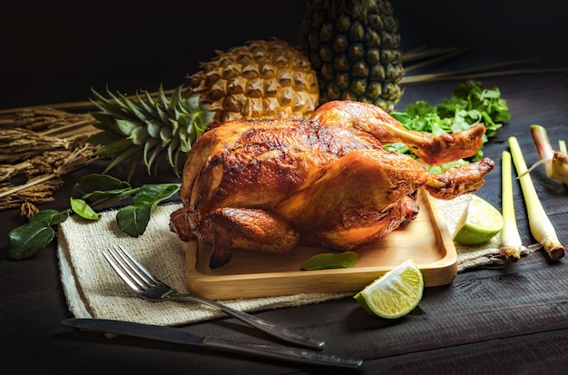 Pollo al horno colocado en un plato de madera