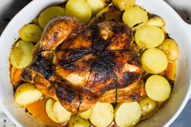 Pollo al horno con guarnición de patatas.