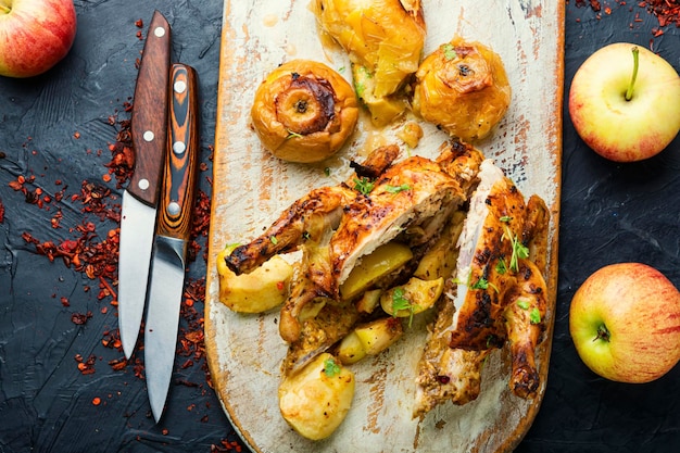 Pollo al horno con manzanas, cortado en rodajas sobre una tabla de cocina