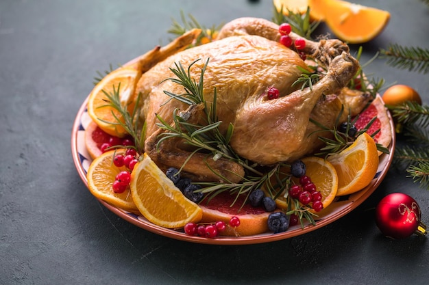 Pollo al horno. La mesa navideña se sirve con un pavo, decorado con frutas brillantes. Cena de Navidad.