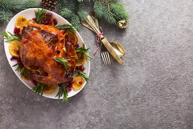 El pollo al horno de Navidad está decorado festivamente con velas.