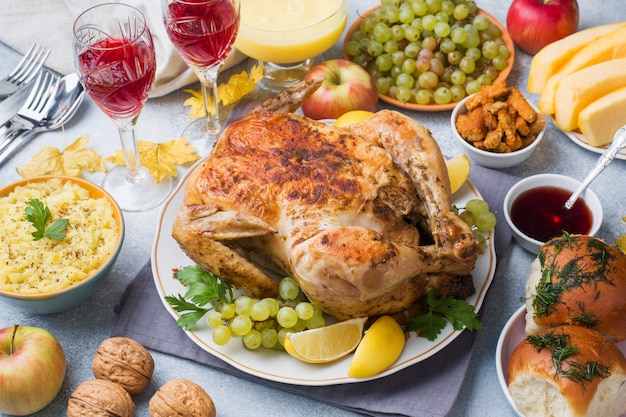 Pollo al horno, puré de papas y copas de vino para la cena en la mesa festiva.