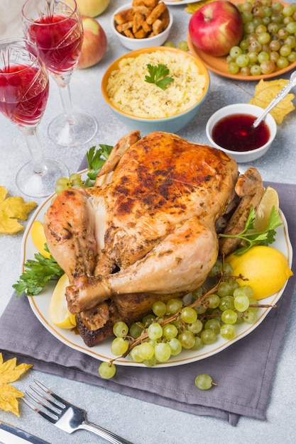 Pollo al horno, puré de papas y copas de vino para la cena en la mesa festiva.