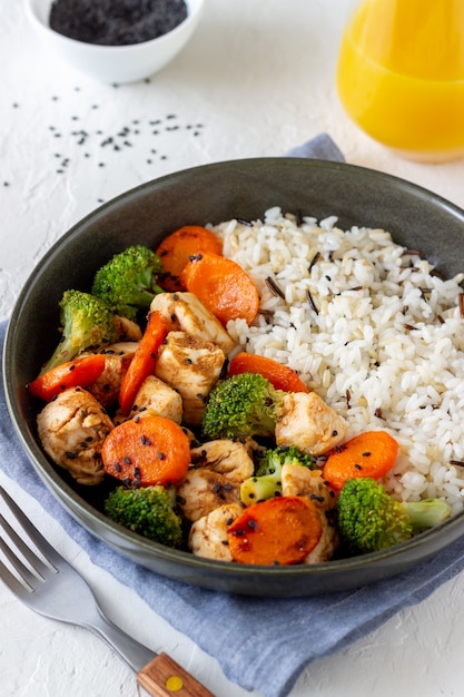 Pollo con arroz, brócoli, zanahoria y salsa de soja. Alimentación saludable. Dieta. Receta.