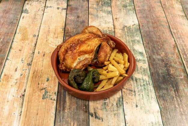 Foto pollo asado de fin de semana con pimientos y papas fritas caseras en una olla de barro