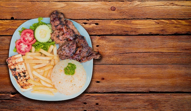 Pollo asado con gallo pinto y pico de gallo comida nicaragüense servida sobre fondo de madera