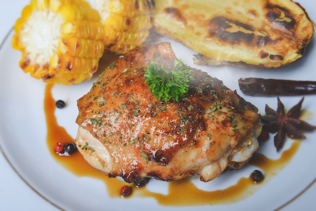 Pollo asado a la parrilla en una placa blanca.