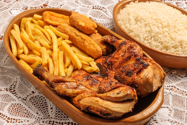 Pollo asado con plátanos empanizados y chips. Plato tradicional de la cocina brasileña.