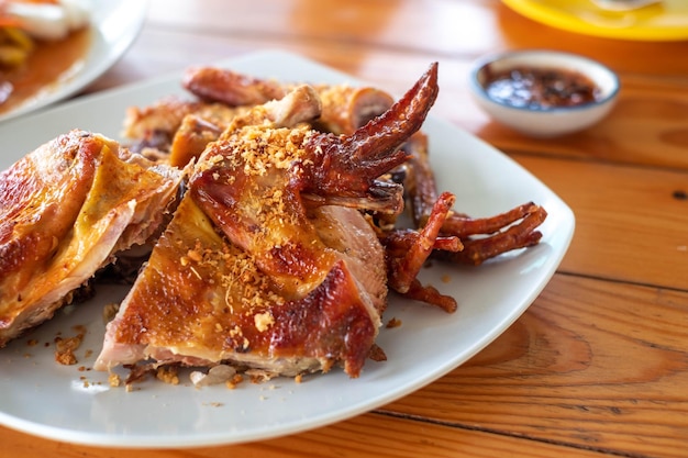 El pollo asado en un plato blanco es una comida local de Tailandia que se puede encontrar en todas las regiones Comer con ensalada de papaya lo mejor posible