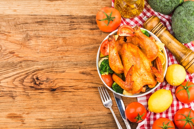 pollo asado y verduras en la mesa de madera