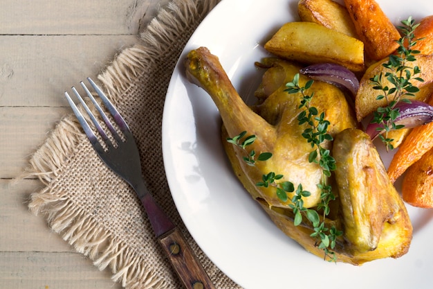 Pollo asado con zanahorias y tomillo.