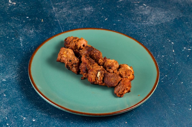 Pollo a la barbacoa picante tikka boti kabab servido en un plato aislado en la vista superior de fondo