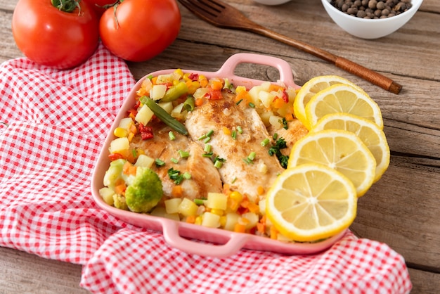 Pollo casero al horno al horno con verduras y vista superior de limón