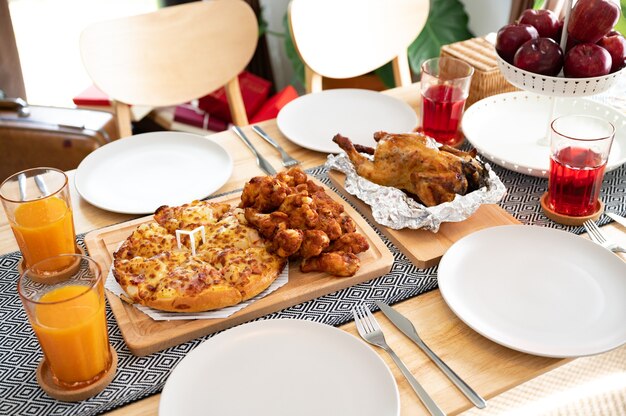 Pollo con comida de pizza en la mesa