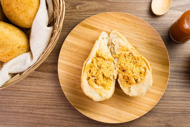 Pollo Coxinha conocido como Coxinha en Brasil Servido en la canasta con especias como limón y pimienta al lado Mesa de madera en el fondo Merienda tradicional brasileña Enfoque selectivo