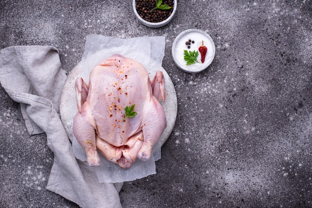 Pollo crudo con hierbas y especias.