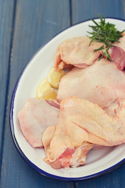 Pollo crudo en plato en marrón