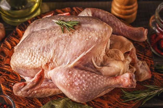 Pollo crudo en tabla de cortar de madera