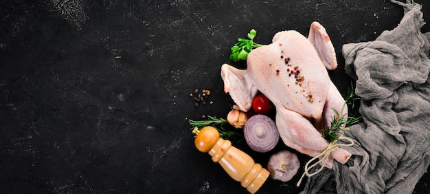 Foto pollo crudo con verduras y especias barbacoa sobre un fondo de piedra negra vista superior espacio de copia libre