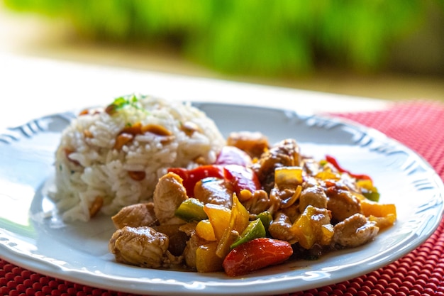 pollo a cuadros comida típica china servida con pollo y pimientos, maní y arroz