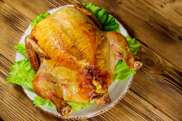 Pollo entero al horno en una mesa de madera Vista superior