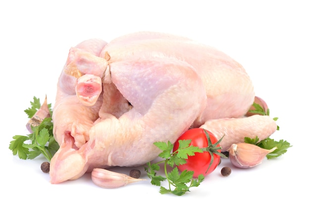Pollo fresco con verduras sobre un fondo blanco.