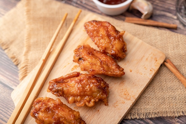 Pollo frito asado coreano caliente y picante en la tabla de cortar de madera