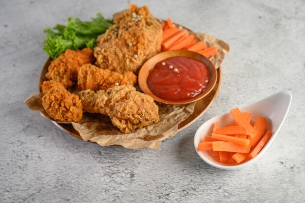 Pollo frito crujiente en un plato con salsa de tomate y zanahoria Foco selectivo