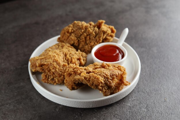 pollo frito crujiente con salsa de tomate con fondo negro