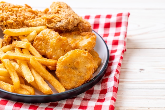 Foto pollo frito con papas fritas y nuggets.