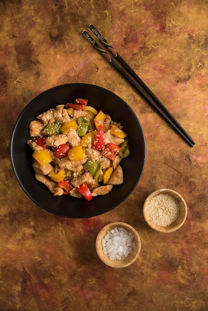 Pollo frito con pimiento rojo amarillo y verde sobre tabla para cortar madera