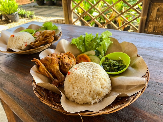 Pollo frito con salsa de chile verde y lechuga fresca servido en un plato tradicional