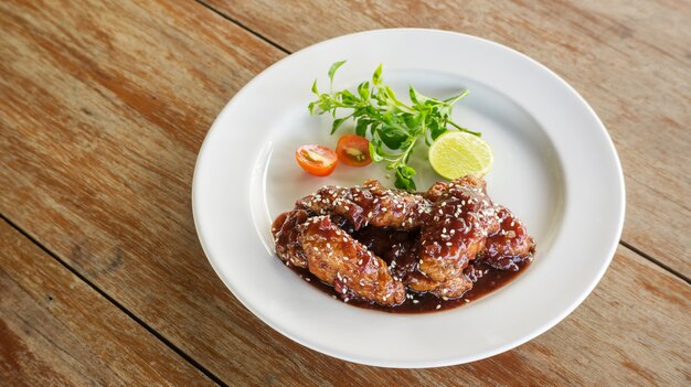 Pollo frito con salsa dulce en un plato blanco.